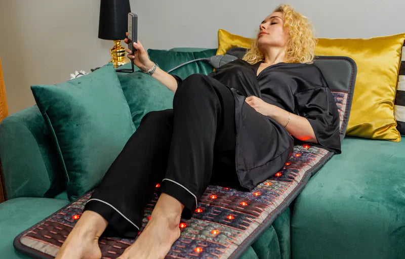 Blondynka w czarnej piżamie leży na macie Dr. Stone PRO na zielonym narożniku. 